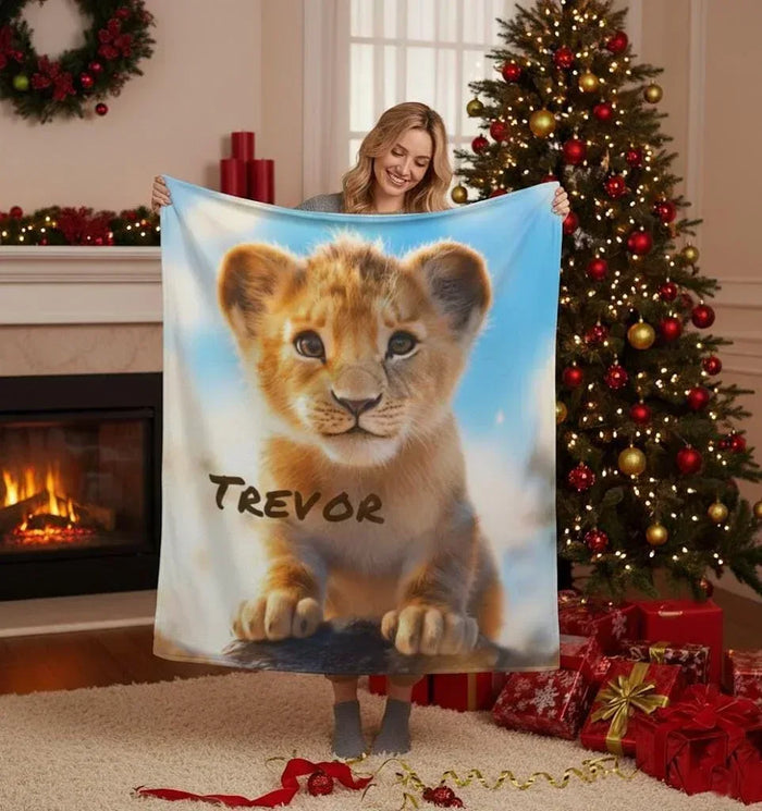 Personalized lion cub baby blanket, blue background, name Trevor printed in brown