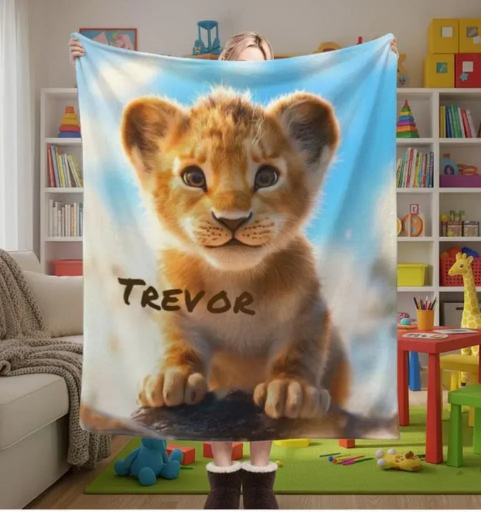 Personalized lion cub baby blanket, blue background, name Trevor printed in dark brown