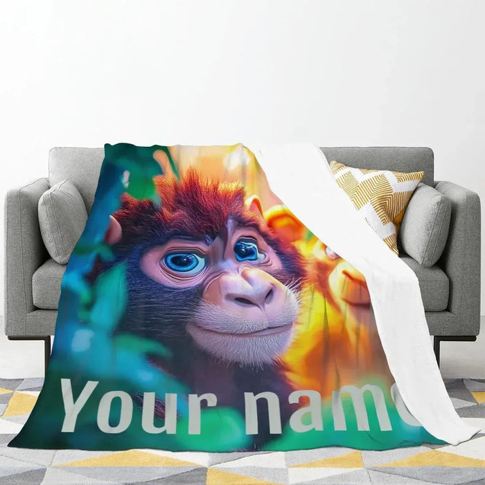 Personalized monkey jungle blanket draped on a sofa with large “Your nam”