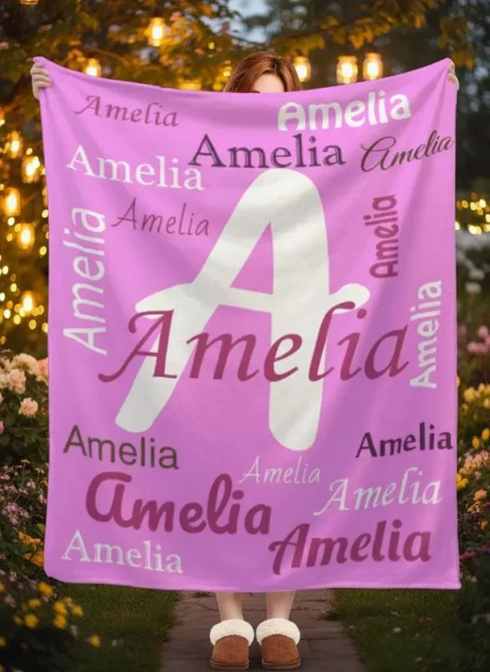 Pink fleece throw blanket with large white letter A and repeated name Amelia