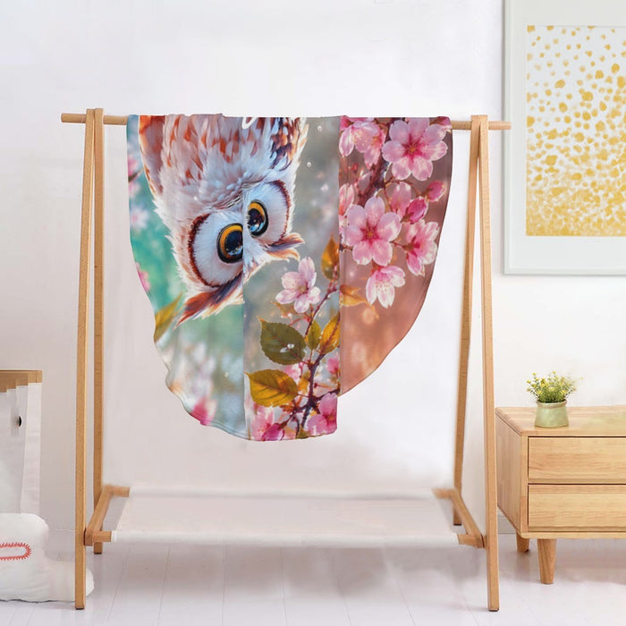 Round owl throw blanket draped on stand, teal background with pink blossom and owl print