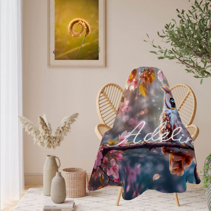 Round owl throw blanket with owl and cherry blossoms, shown draped over chair
