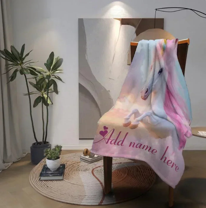 Unicorn fleece blanket folded on a stand with pastel unicorn print and name text