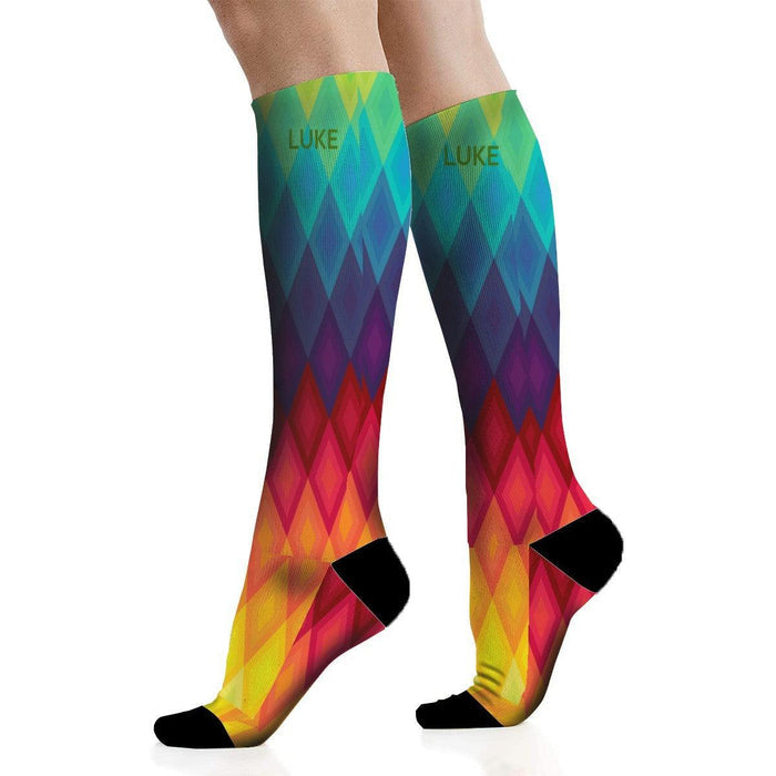 Mid-calf rainbow socks on feet, chevron diamond pattern, black toe and heel bands