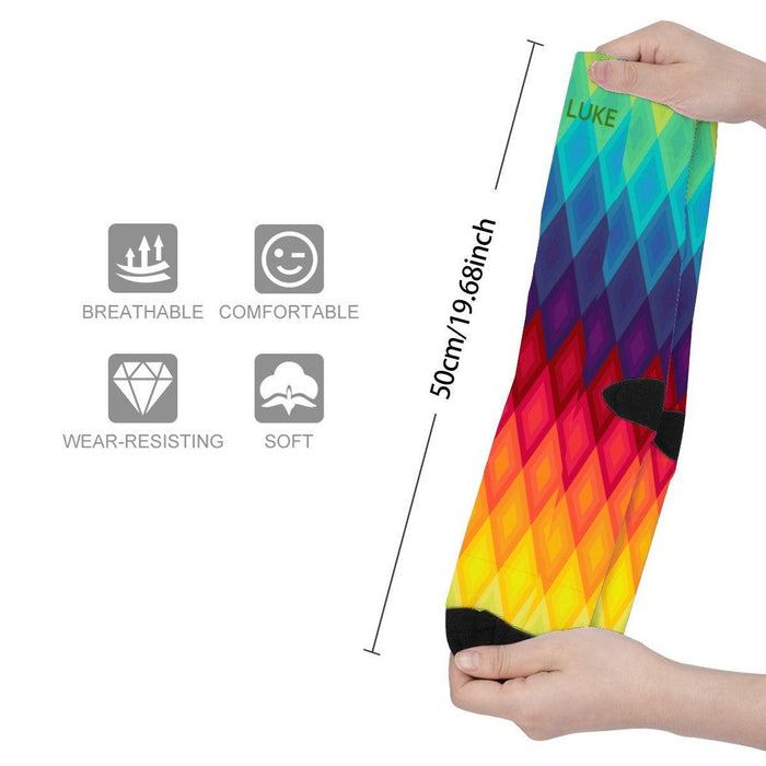 Mid-calf rainbow socks with multicolor chevron diamonds, black toe panel, stretch view