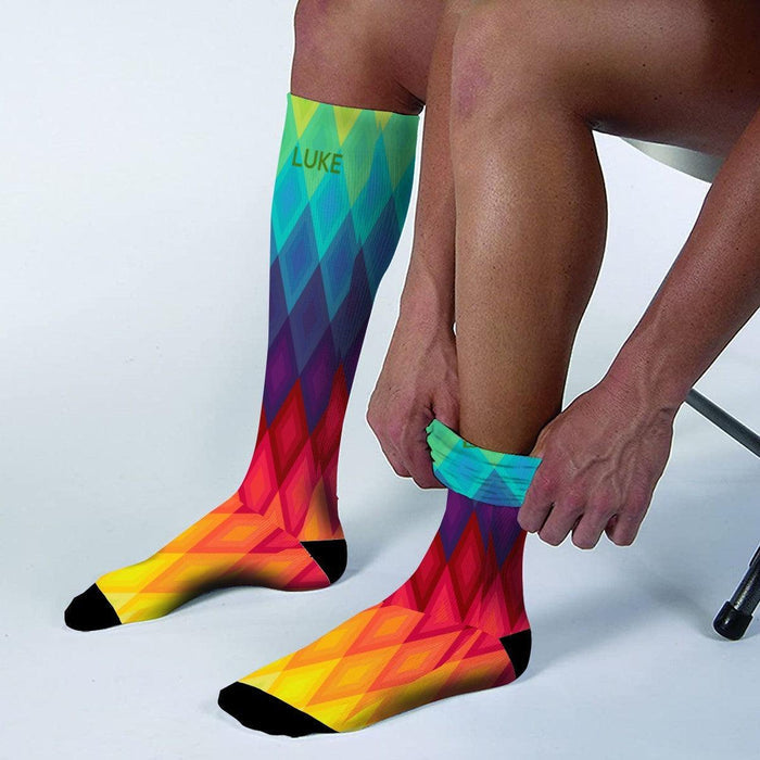 Mid-calf rainbow socks worn with yellow-orange chevron pattern, black toe and heel