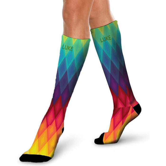 Mid-calf rainbow socks with chevron diamond pattern, black toe and heel, worn stance