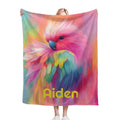 Personalized rainbow parrot blanket held up, pink blue green feathers with 'Aiden'.