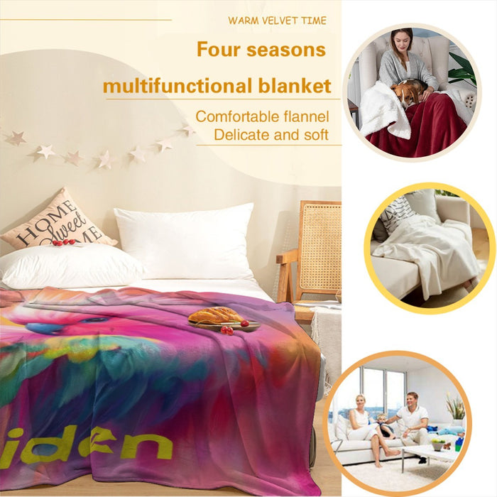 Rainbow parrot blanket on bed with 'Aiden' lettering and multicolor feather pattern.