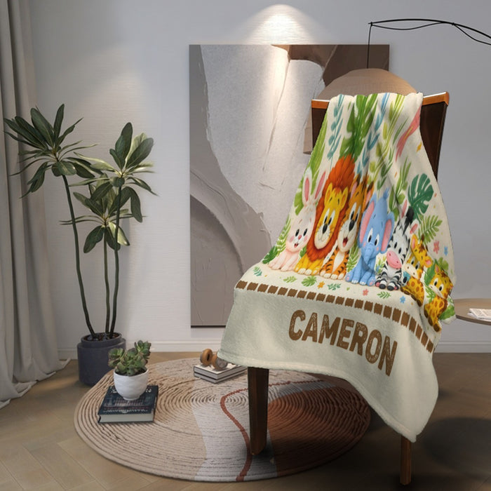 Personalized safari animal blanket draped on chair with “CAMERON” lettering