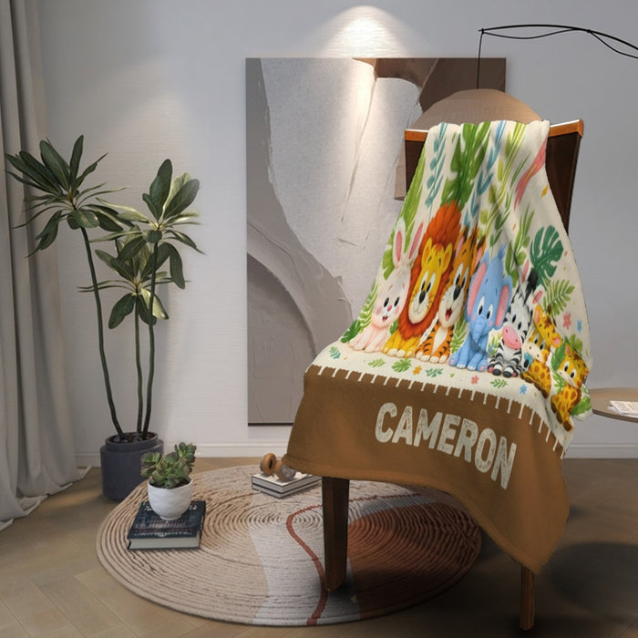 Personalized safari blanket draped on chair, white top with animal illustration and CAMERON