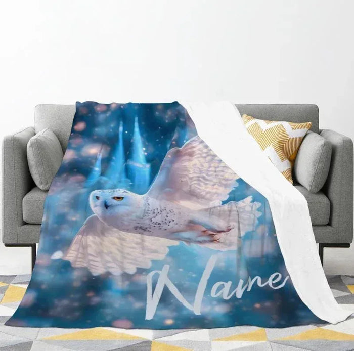 Flannel fleece throw with owl wings and name Melanie draped on sofa
