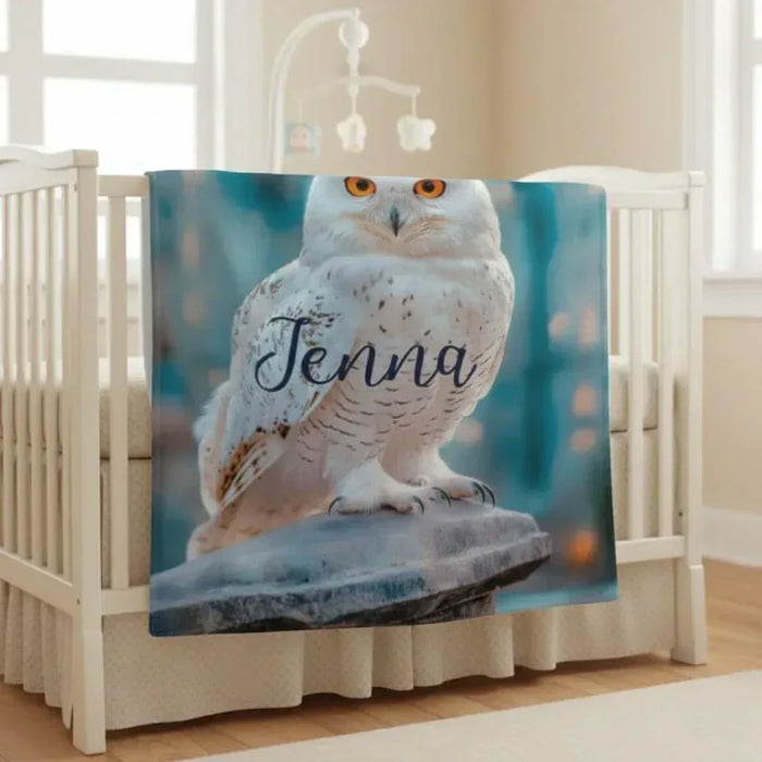 Personalized owl blanket draped on a railing, showing white owl and script name