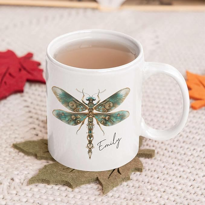 White ceramic mug with teal steampunk dragonfly and name Emily, filled with coffee