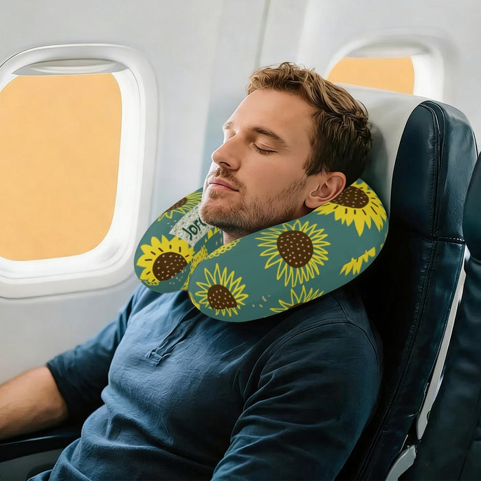 Sunflower printed neck pillow in use around a man’s neck on an airplane seat