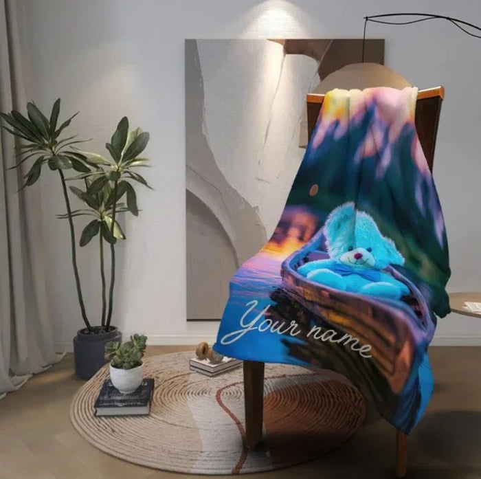 Personalized flannel fleece throw blanket draped on chair with bear canoe artwork