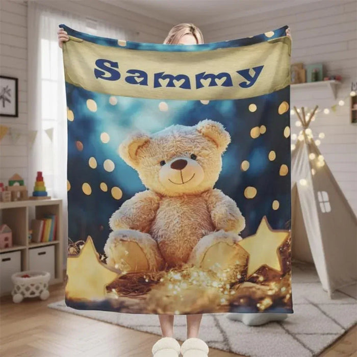 Teddy bear plush blanket with blue star print, teddy holding string lights, name panel