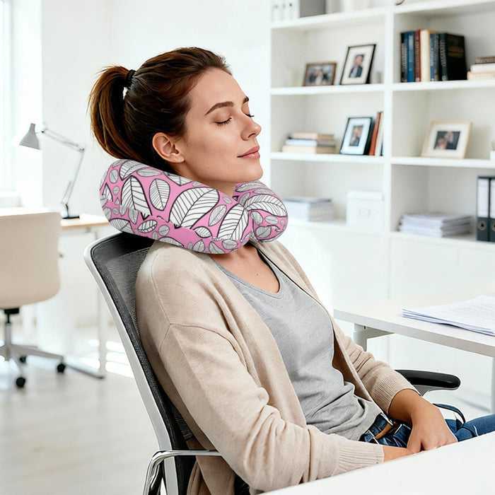 Leaf-print travel neck pillow worn on a woman’s neck, pink and gray U-shape
