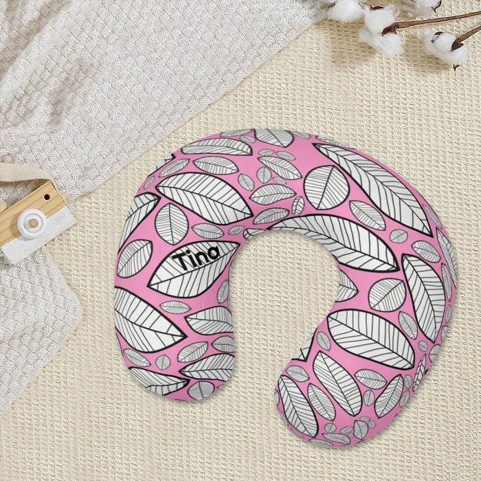 U-shaped neck pillow with pink leaf-and-vein sketch pattern on a light fabric