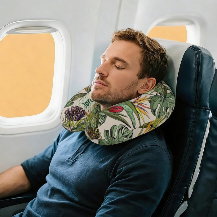 Person resting with personalized travel neck pillow, green tropical botanical print