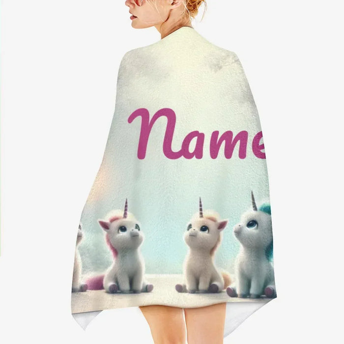 Personalized unicorn beach towel, light gray with pink “Name” and three seated unicorns