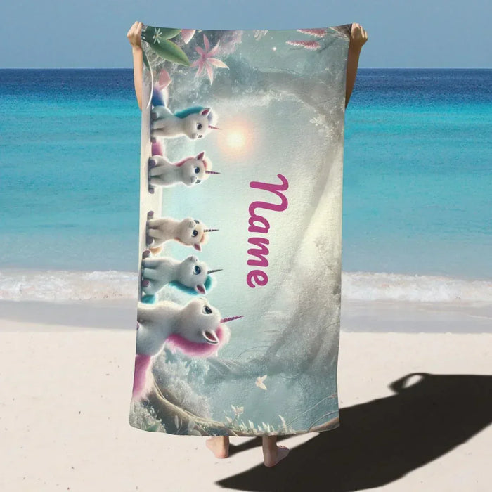 Unicorn beach towel with vertical pink “name” text and unicorn characters, light gray-blue