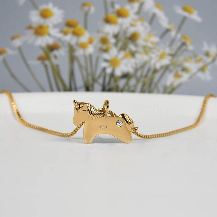 Gold unicorn birthstone necklace with name Julia and small clear gemstone pendant
