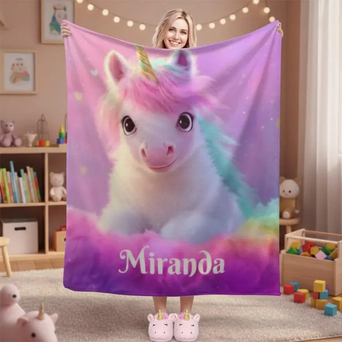 Unicorn fleece throw blanket, pink with rainbow accents and a cute white unicorn face.