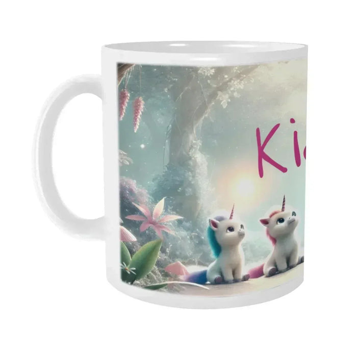 White ceramic mug with handle; unicorn kittens in a forest scene and partial Kiara text
