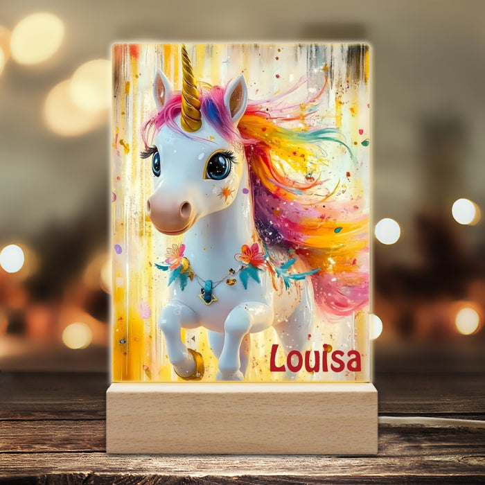 Unicorn night light on a wooden base with colorful mane and “Louisa” name