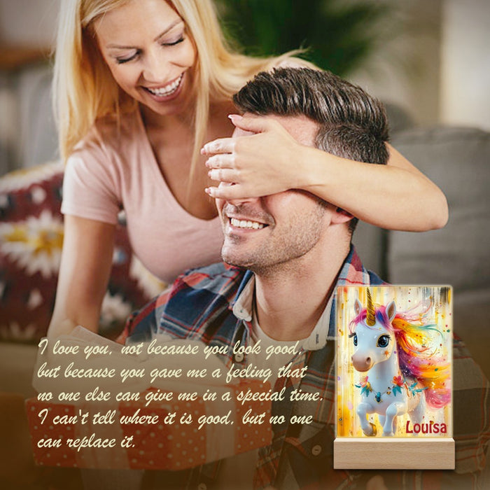 Unicorn night light on wooden base, shown with smiling family and “Louisa” text