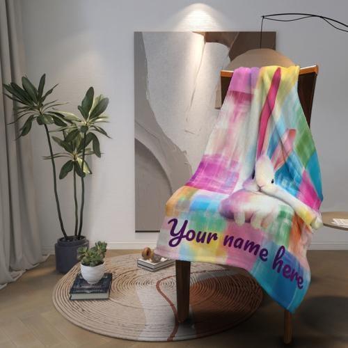 Rainbow patchwork bunny blanket on a chair with “Your name here” printed across