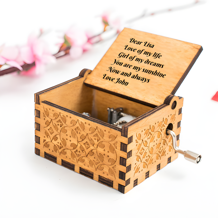Engraved wooden music box with floral carvings, hinged lid and side crank handle