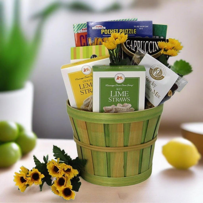 Care package gift basket with green bucket and boxed lime and lemon straw snacks.