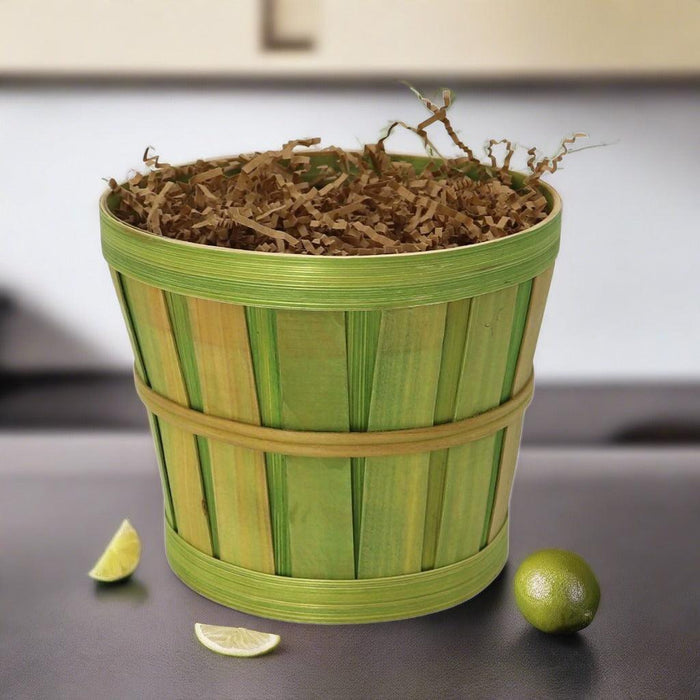 Green striped care package basket filled with shredded filler and lime pieces.
