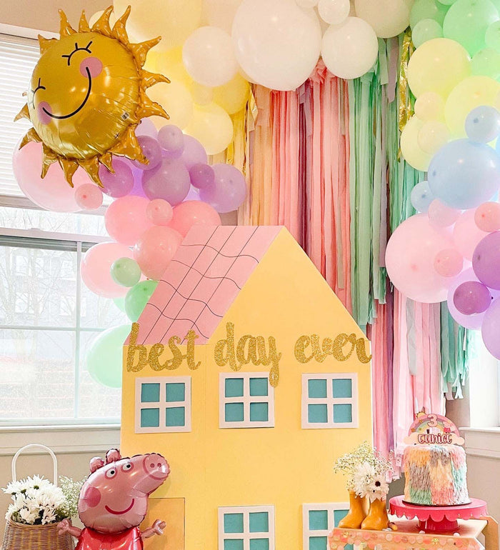 Pastel balloon garland with pink and white balloons and a sun-shaped topper
