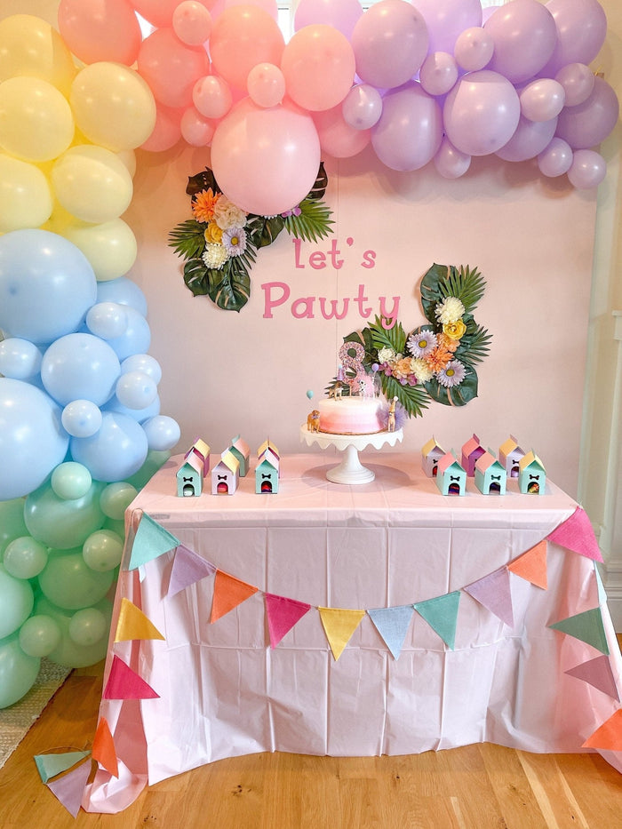 Pastel balloon garland backdrop with pink, purple, yellow, and blue balloons