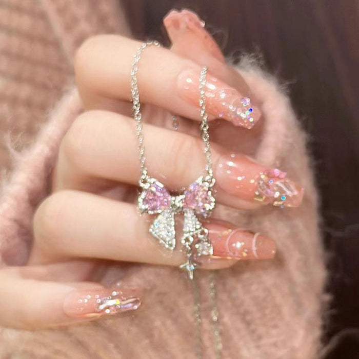 Pink bow pendant necklace with sparkle bow center and hanging star charm on silver-tone chain