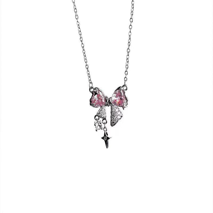 Pink bow pendant necklace with dangling star charm on silver-tone chain