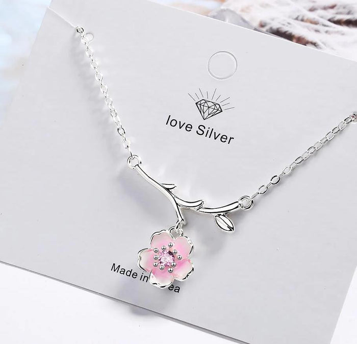 Silver necklace with pink cherry blossom pendant and curved branch charm