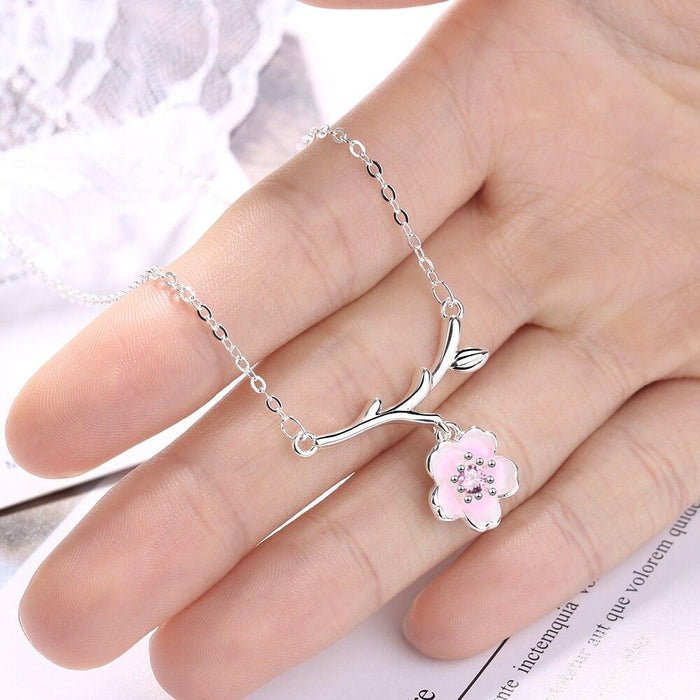 Silver cherry blossom necklace with pink flower pendant shown on hand