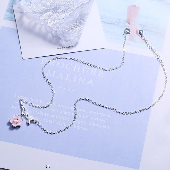 Silver cherry blossom necklace with pink flower charms on display card