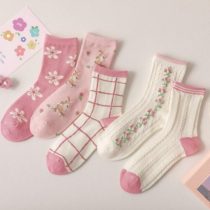 Assorted floral crew socks in pink and cream, with daisy, grid, and vine prints.