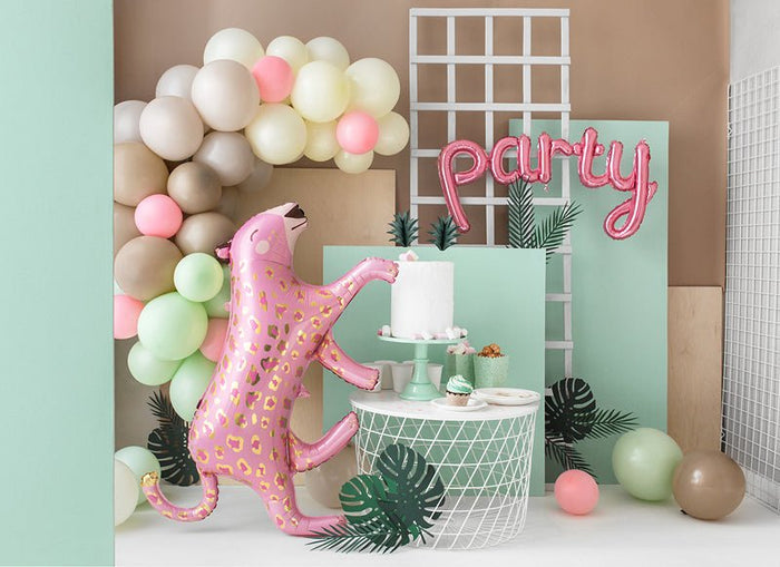 Pink leopard-print dog balloon standing near a multi-tier cake and pastel balloon décor.