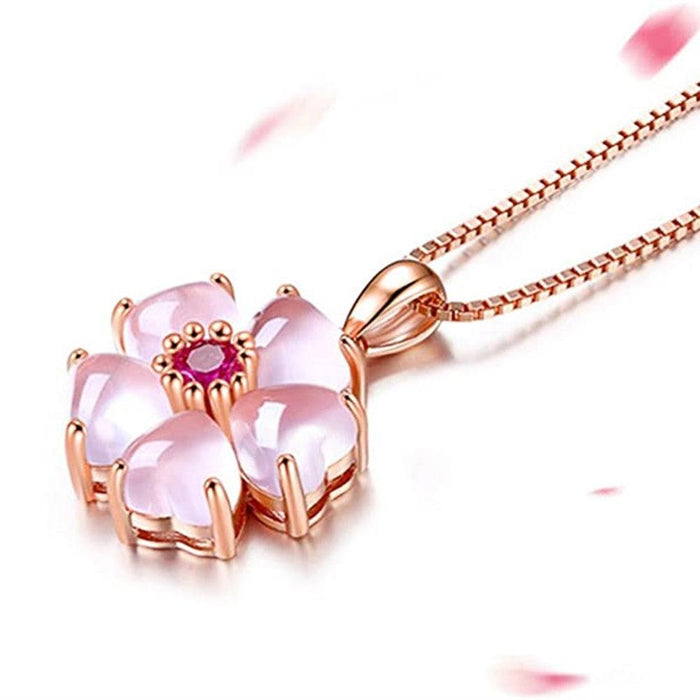Rose-gold sakura pendant necklace with pink flower charm and magenta gemstone centerpiece