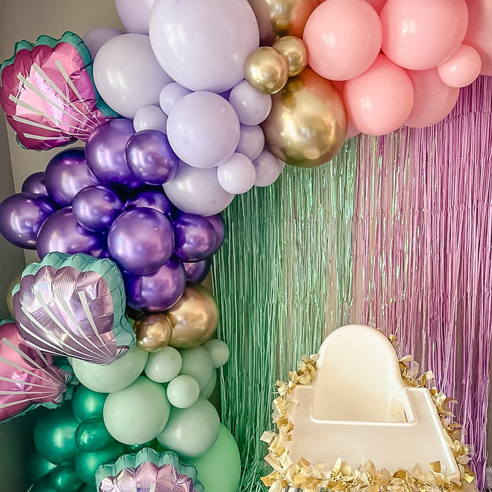 Seashell-shaped balloon in pink and purple within a pastel balloon bouquet