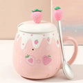 Pink ceramic mug with white lid, strawberry topper, and spoon; strawberry heart print