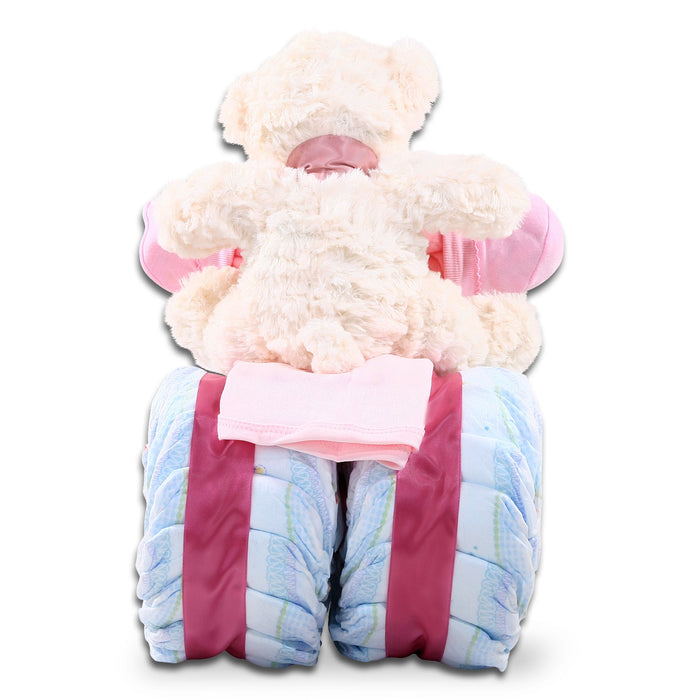 Pink tricycle diaper cake gift basket, back view with bear plush and pink straps, blue diapers