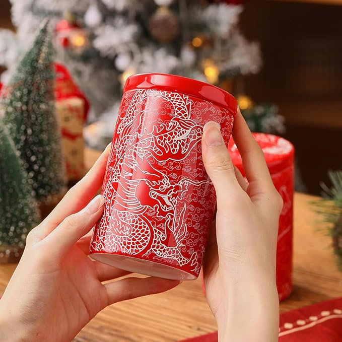 Hand holding a red porcelain canister with white dragon pattern and round lid