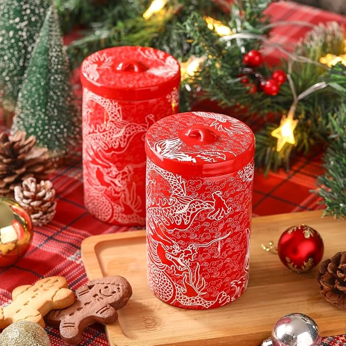 Two red porcelain canisters with white dragon motif on top and matching lids